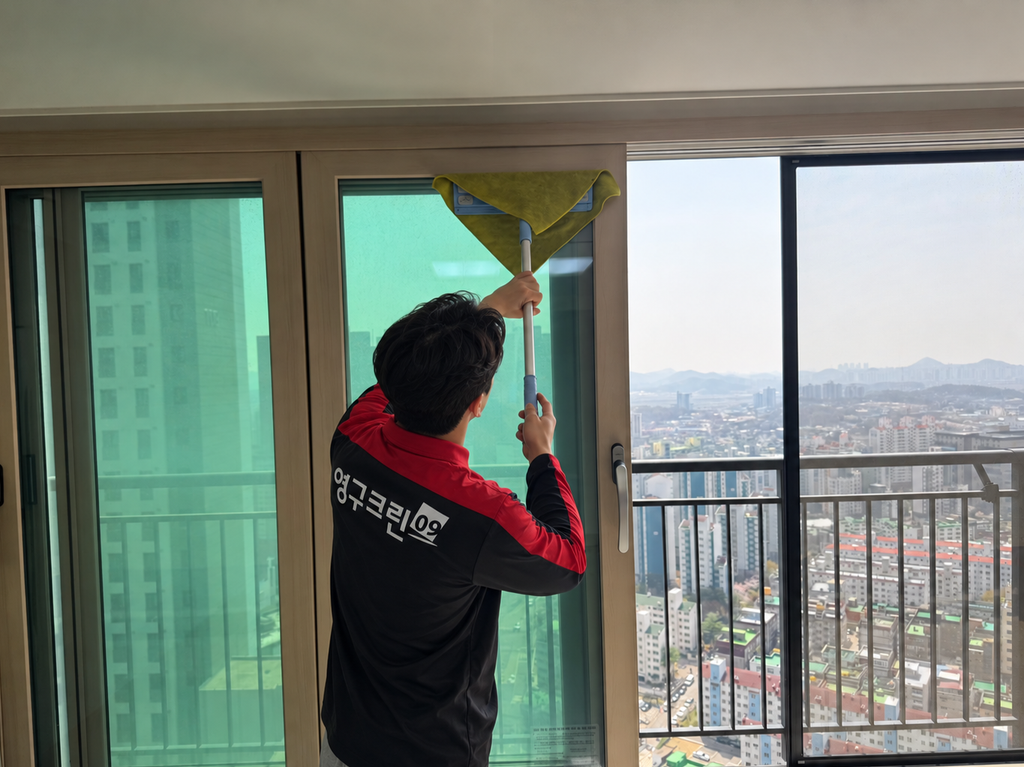 입주청소 영구크린 크린마스터가 스퀴지로 유리창을 닦는 모습